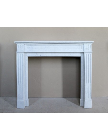 Louis XVI “Cannelure” fireplace mantel carved in “Pure” Bianco Carrara marble. A sober, elegant, and linear antique fireplace.