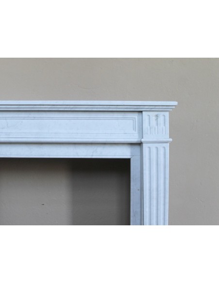 Louis XVI “Cannelure” fireplace mantel carved in “Pure” Bianco Carrara marble. A sober, elegant, and linear antique fireplace.