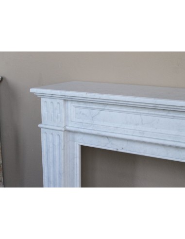 Louis XVI “Cannelure” fireplace mantel carved in “Pure” Bianco Carrara marble. A sober, elegant, and linear antique fireplace.