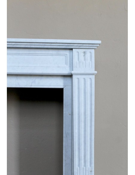 Louis XVI “Cannelure” fireplace mantel carved in “Pure” Bianco Carrara marble. A sober, elegant, and linear antique fireplace.