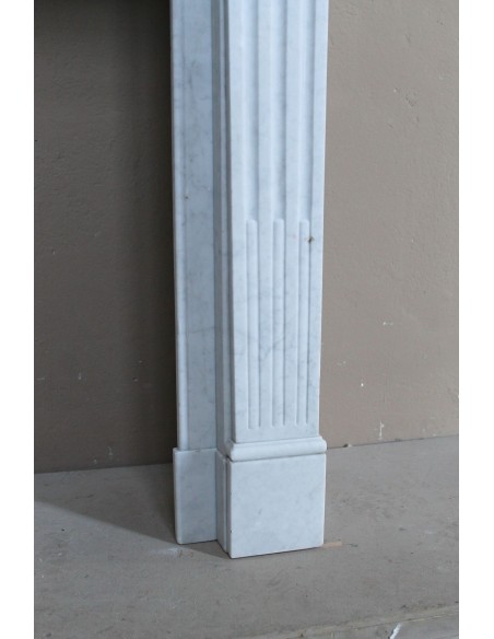 Louis XVI “Cannelure” fireplace mantel carved in “Pure” Bianco Carrara marble. A sober, elegant, and linear antique fireplace.