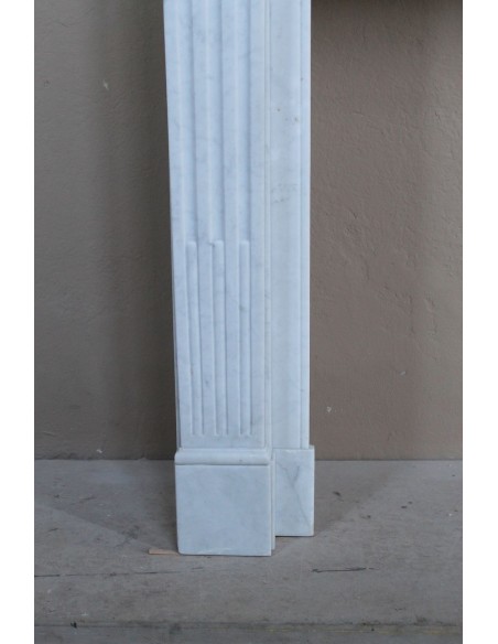 Louis XVI “Cannelure” fireplace mantel carved in “Pure” Bianco Carrara marble. A sober, elegant, and linear antique fireplace.