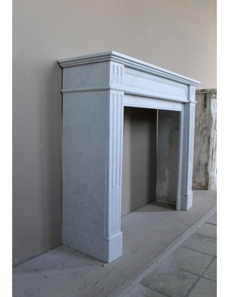 Louis XVI “Cannelure” fireplace mantel carved in “Pure” Bianco Carrara marble. A sober, elegant, and linear antique fireplace.