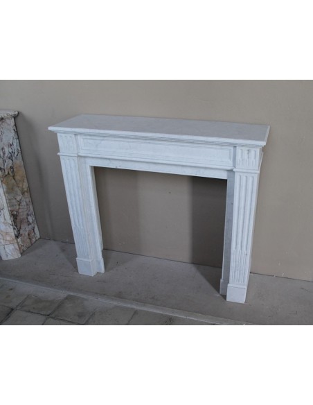 Louis XVI “Cannelure” fireplace mantel carved in “Pure” Bianco Carrara marble. A sober, elegant, and linear antique fireplace.