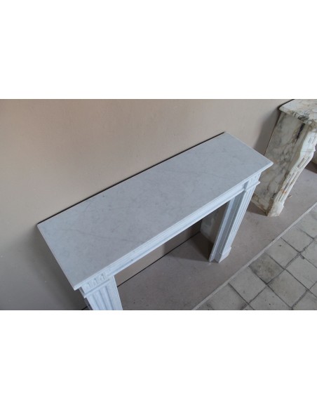 Louis XVI “Cannelure” fireplace mantel carved in “Pure” Bianco Carrara marble. A sober, elegant, and linear antique fireplace.