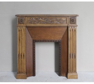 Charming small-scale Louis XVI “Olive Branch” fireplace mantel carved in oak wood, complete with insert and closure.