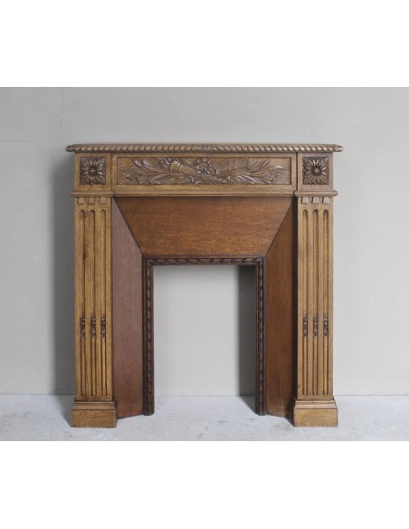Charming small-scale Louis XVI “Olive Branch” fireplace mantel carved in oak wood, complete with insert and closure.