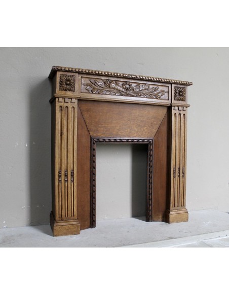 Charming small-scale Louis XVI “Olive Branch” fireplace mantel carved in oak wood, complete with insert and closure.