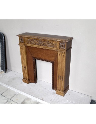 Charming small-scale Louis XVI “Olive Branch” fireplace mantel carved in oak wood, complete with insert and closure.