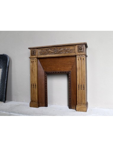 Charming small-scale Louis XVI “Olive Branch” fireplace mantel carved in oak wood, complete with insert and closure.