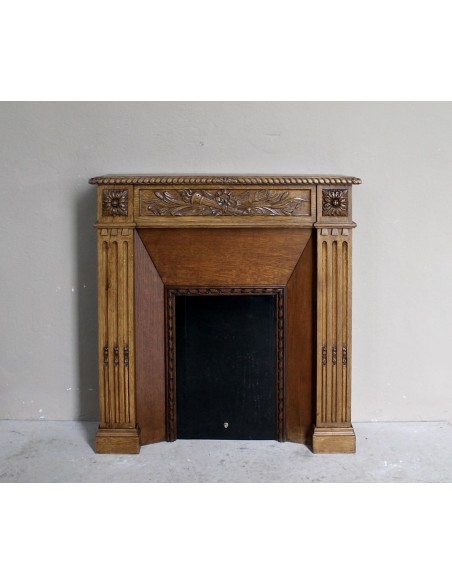 Charming small-scale Louis XVI “Olive Branch” fireplace mantel carved in oak wood, complete with insert and closure.