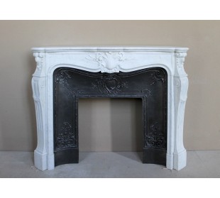 A refined antique white marble mantel in the Baroque style, carved with floral motifs, with its original cast iron insert.