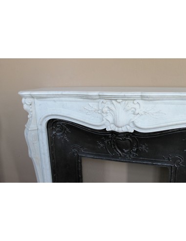 A refined antique white marble mantel in the Baroque style, carved with floral motifs, with its original cast iron insert.