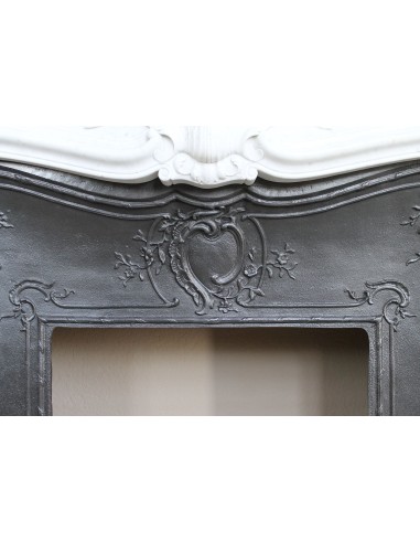 A refined antique white marble mantel in the Baroque style, carved with floral motifs, with its original cast iron insert.