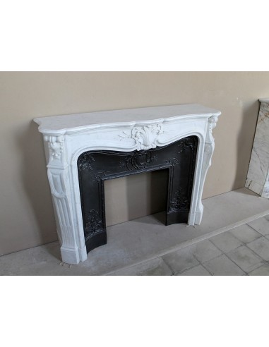 A refined antique white marble mantel in the Baroque style, carved with floral motifs, with its original cast iron insert.