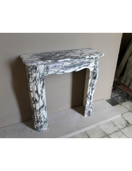 Louis XV “Pompadour” fireplace mantel in Breccia Medicea marble, featuring strong purple, green, gold and white veining.