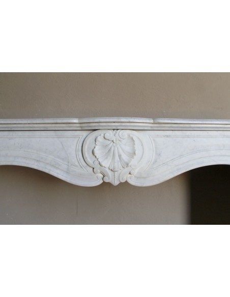 Louis XV “Coquille” fireplace mantel in white marble with sculpted shell decorations. A genuine antique marble fire surround.