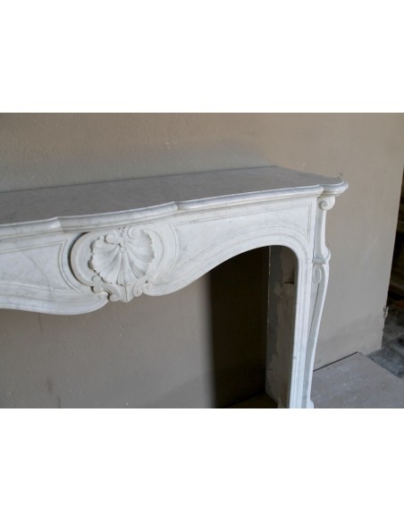 Louis XV “Coquille” fireplace mantel in white marble with sculpted shell decorations. A genuine antique marble fire surround.