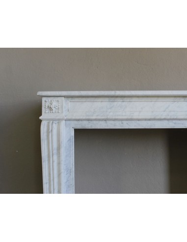 Small and well-proportioned Neoclassical fireplace with curved shoulders in white marble, an elegant and refined fire surround.