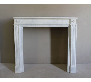 Small and well-proportioned Neoclassical fireplace with curved shoulders in white marble, an elegant and refined fire surround.