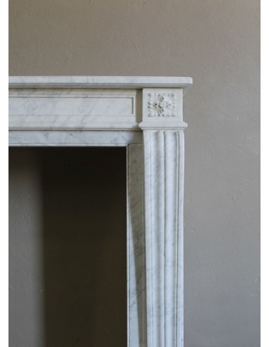 Small and well-proportioned Neoclassical fireplace with curved shoulders in white marble, an elegant and refined fire surround.