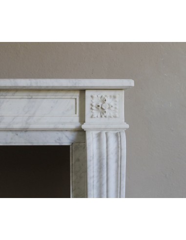Small and well-proportioned Neoclassical fireplace with curved shoulders in white marble, an elegant and refined fire surround.