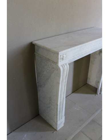 Small and well-proportioned Neoclassical fireplace with curved shoulders in white marble, an elegant and refined fire surround.