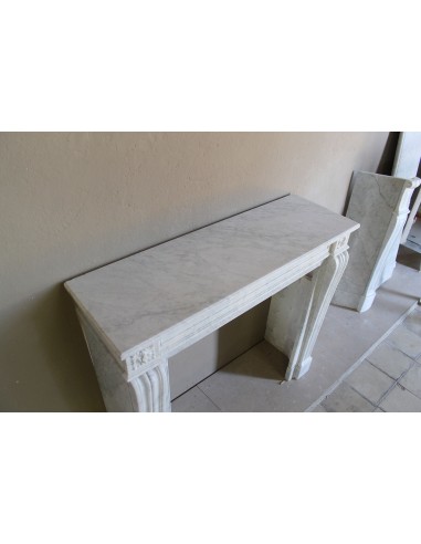 Small and well-proportioned Neoclassical fireplace with curved shoulders in white marble, an elegant and refined fire surround.