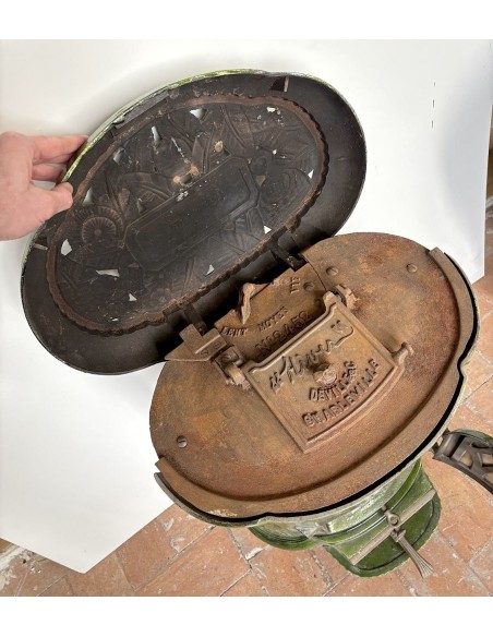 Antique Deville “Hiver” stove in green enameled cast iron, with floral decorative elements, from the Art Deco period.
