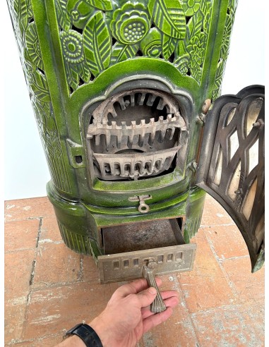 Antique Deville “Hiver” stove in green enameled cast iron, with floral decorative elements, from the Art Deco period.