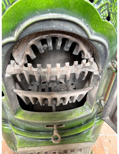 Antique Deville “Hiver” stove in green enameled cast iron, with floral decorative elements, from the Art Deco period.