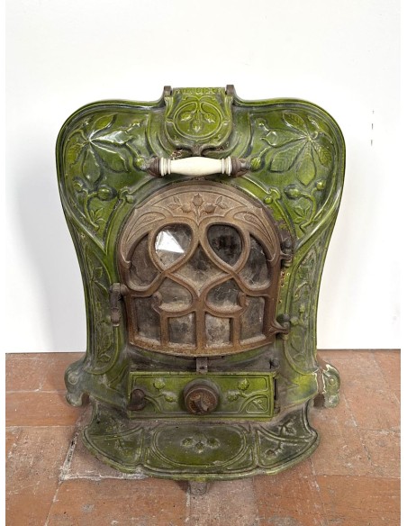 Antique “Lux” stove in green enameled cast iron, with floral and foliate decorations. A genuine and rare fireplace stove.