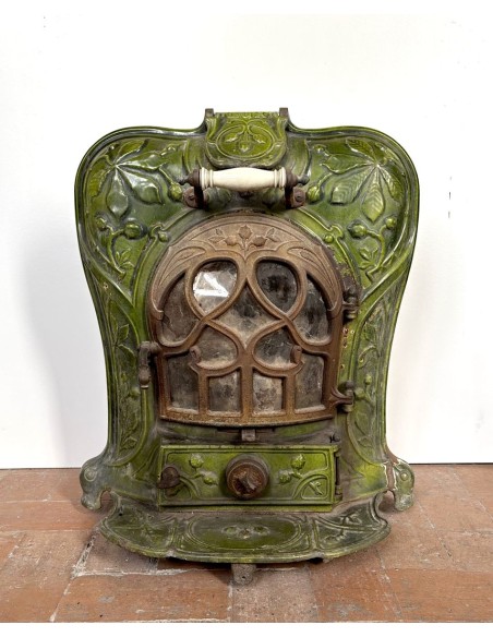 Antique “Lux” stove in green enameled cast iron, with floral and foliate decorations. A genuine and rare fireplace stove.
