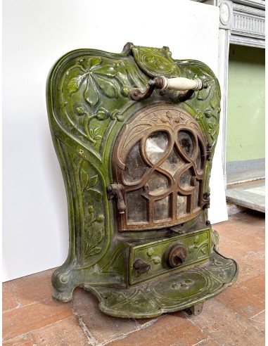 Antique “Lux” stove in green enameled cast iron, with floral and foliate decorations. A genuine and rare fireplace stove.