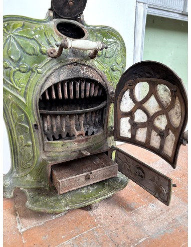 Antique “Lux” stove in green enameled cast iron, with floral and foliate decorations. A genuine and rare fireplace stove.