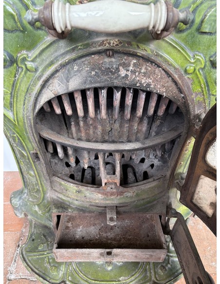 Antique “Lux” stove in green enameled cast iron, with floral and foliate decorations. A genuine and rare fireplace stove.