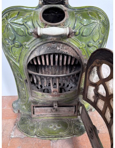 Antique “Lux” stove in green enameled cast iron, with floral and foliate decorations. A genuine and rare fireplace stove.
