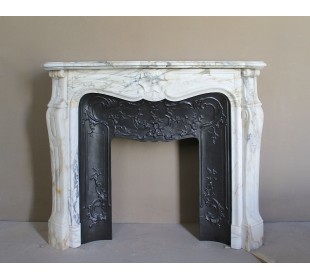 An antique refined Louis XV “Coquille” fireplace mantel in Calacatta Gold marble with its original floral cast-iron insert.