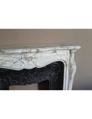 An antique refined Louis XV “Coquille” fireplace mantel in Calacatta Gold marble with its original floral cast-iron insert.