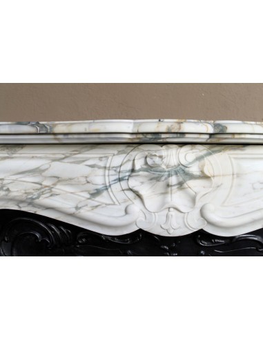 An antique refined Louis XV “Coquille” fireplace mantel in Calacatta Gold marble with its original floral cast-iron insert.