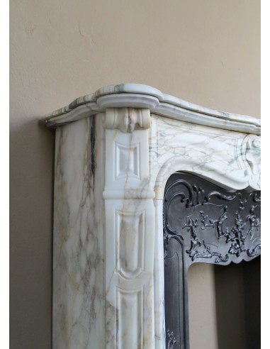 An antique refined Louis XV “Coquille” fireplace mantel in Calacatta Gold marble with its original floral cast-iron insert.