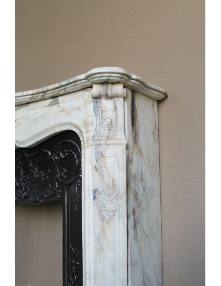 An antique refined Louis XV “Coquille” fireplace mantel in Calacatta Gold marble with its original floral cast-iron insert.