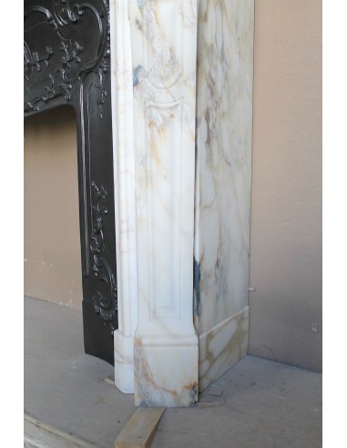 An antique refined Louis XV “Coquille” fireplace mantel in Calacatta Gold marble with its original floral cast-iron insert.