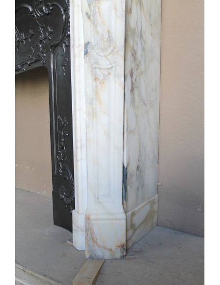 An antique refined Louis XV “Coquille” fireplace mantel in Calacatta Gold marble with its original floral cast-iron insert.