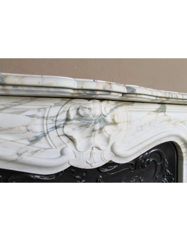 An antique refined Louis XV “Coquille” fireplace mantel in Calacatta Gold marble with its original floral cast-iron insert.