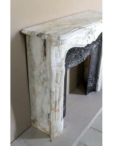 An antique refined Louis XV “Coquille” fireplace mantel in Calacatta Gold marble with its original floral cast-iron insert.