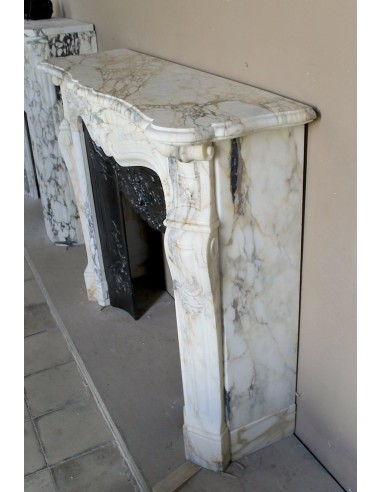 An antique refined Louis XV “Coquille” fireplace mantel in Calacatta Gold marble with its original floral cast-iron insert.