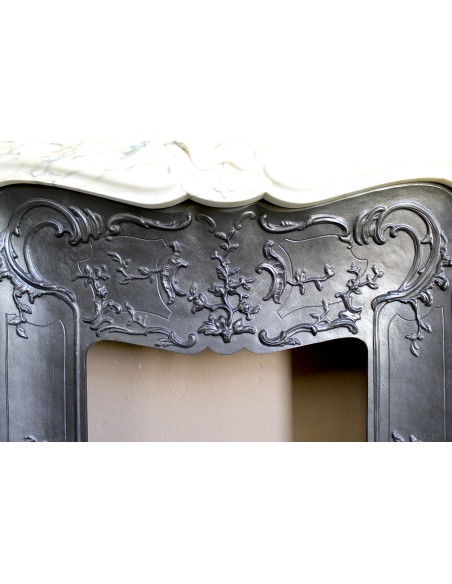 An antique refined Louis XV “Coquille” fireplace mantel in Calacatta Gold marble with its original floral cast-iron insert.