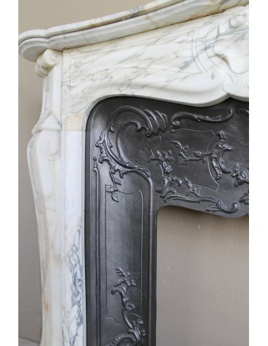 An antique refined Louis XV “Coquille” fireplace mantel in Calacatta Gold marble with its original floral cast-iron insert.