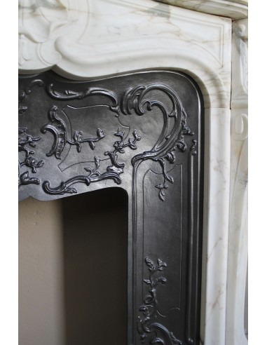 An antique refined Louis XV “Coquille” fireplace mantel in Calacatta Gold marble with its original floral cast-iron insert.
